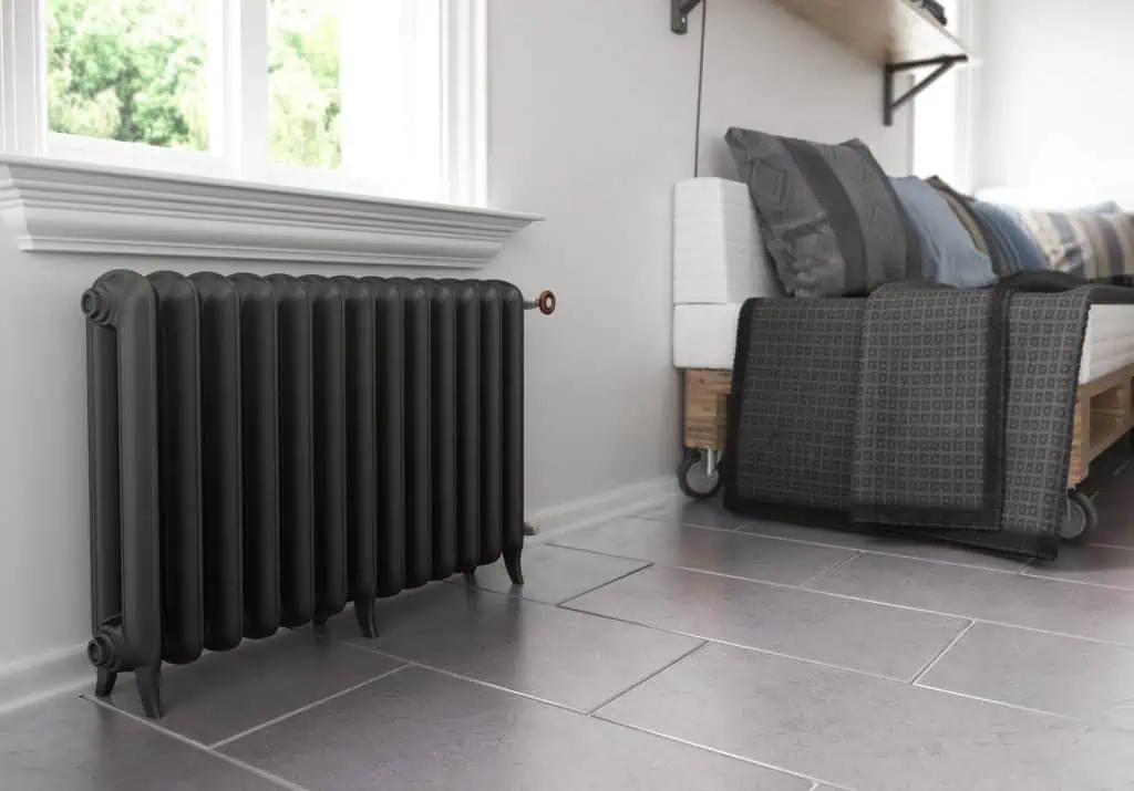 Vintage black cast iron radiator in modern home interior.