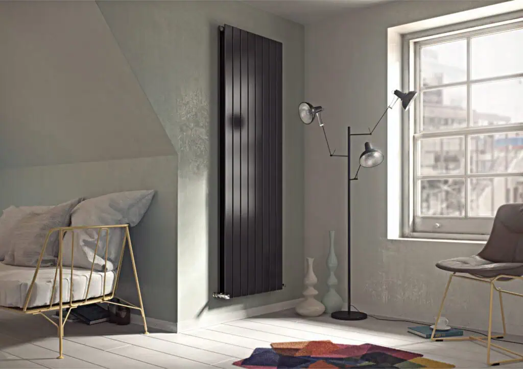 Black vertical radiator in modern living room, energy-efficient heating solution.