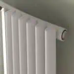 Radiator heating system for home or office, modern white radiator with valve.