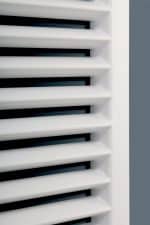 Pollution control louver vents in modern building interior, white and black louvered design.