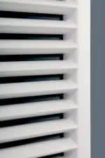 Pollution control louver vents in modern building interior, white and black louvered design.