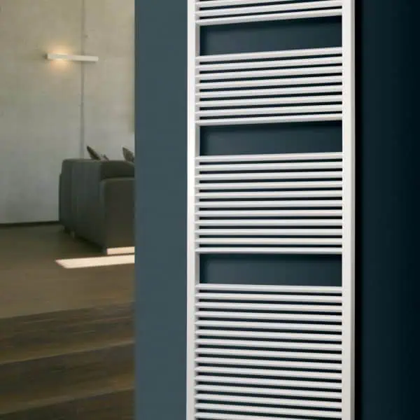 Radiator towel warmer in modern bathroom, white heated towel rail for home comfort and heat efficiency.