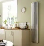 Radiator heating system in modern kitchen, energy-efficient wall mounted radiator design, home heating solution, wall-mounted chrome radiator, eco-friendly heating appliance.