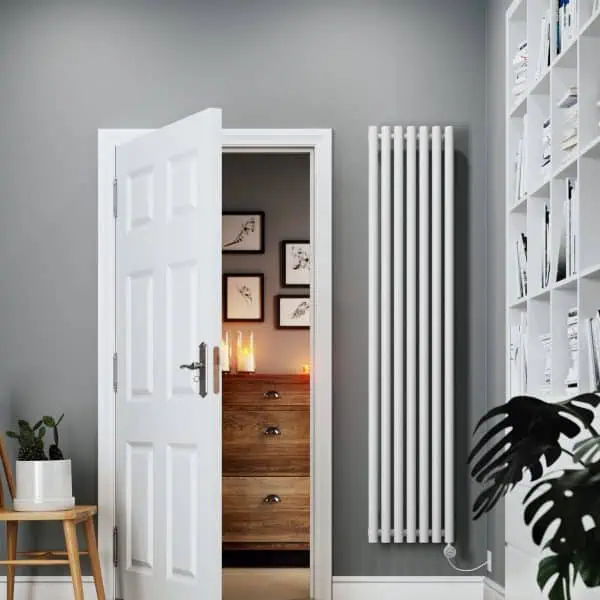 Modern gray living room with white door, radiator, and bookshelf, stylish interior decor.