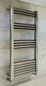 Polished stainless steel towel radiator for bathrooms, wall-mounted, modern heating solution.