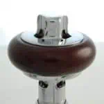 Polished metal Dyson vacuum cleaner part with wooden handle, industrial design.