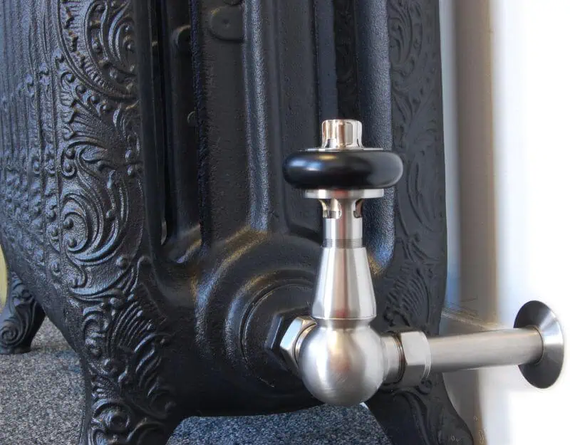 FAR-CR-COM2_800-1.jpg Vintage black cast iron radiator with silver tap detail for heating and decoration.