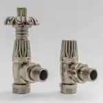 Shiny silver radiator valves for heating system, close-up of modern plumbing components.