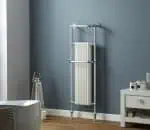 Shower radiator with chrome finish in modern bathroom setting.