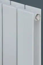 Radiator heating system close-up, modern white panel radiator, energy-efficient heating solution for homes and offices.
