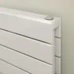 Clean white radiator with modern heating controls in a contemporary home.