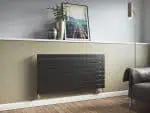 Modern black radiator heating panel in contemporary living room setting.