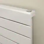 Radiator with modern white finish and adjustable thermostat control, ideal for home heating solutions.