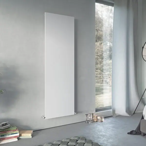 Modern vertical white panel radiator in a contemporary bedroom setting.
