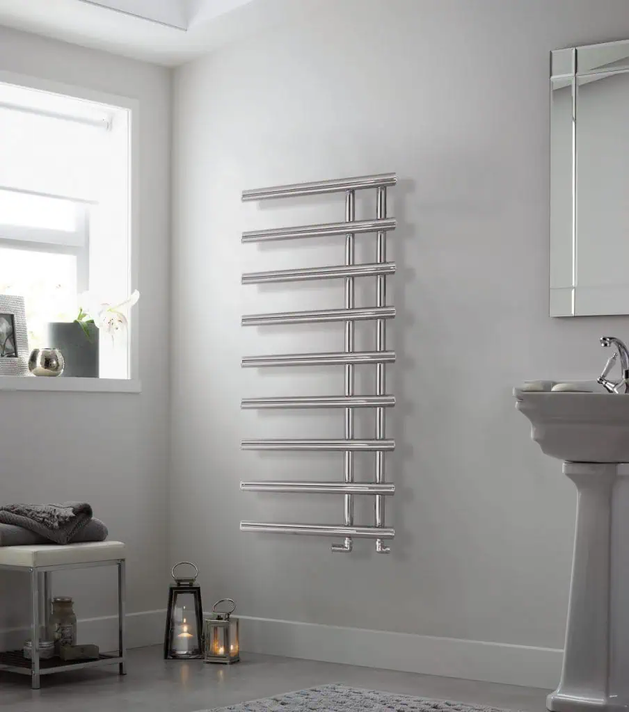 Polished stainless steel heated towel rail in a modern bathroom setting.