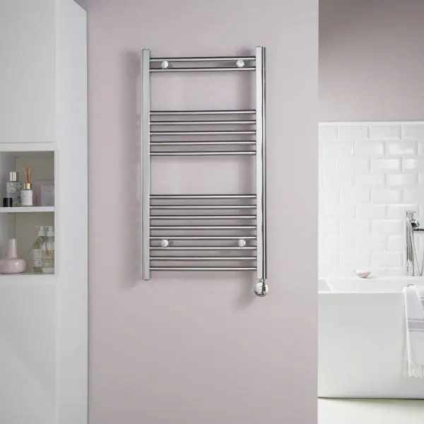 Polished chrome towel radiator heater in modern bathroom setting.