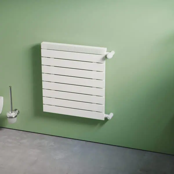 Modern white radiator on green bathroom wall for heating and decor.