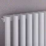 Modern white radiator for home heating, close-up shot.
