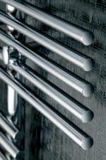 Sleek stainless steel drawer handles on textured wall, modern industrial design elements.