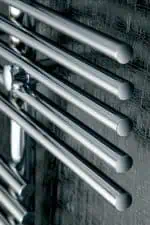 Sleek stainless steel drawer handles on textured wall, modern industrial design elements.