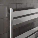 Durable aluminum heated towel rail for bathrooms, modern design, black tile backsplash.