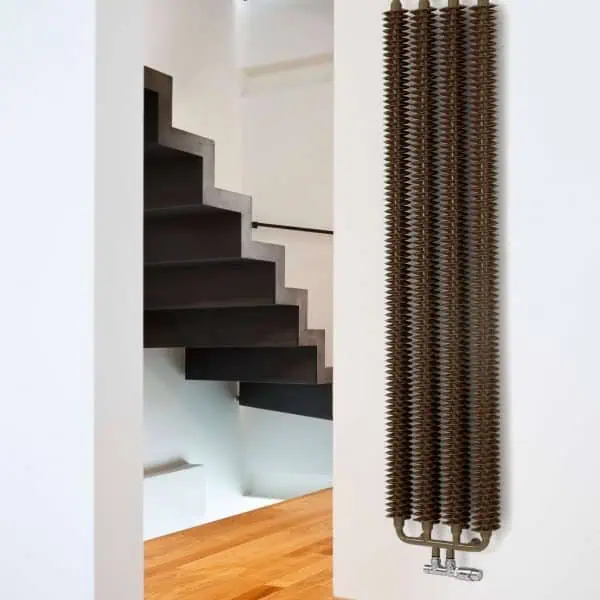 Industrial radiator heater with modern staircase in contemporary home setting.