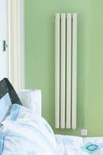 Radiator heating system in a modern bedroom with green wall - efficient home heating solutions.