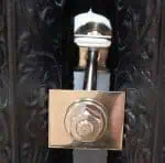 Door lock with decorative black wood background, emphasizing security and craftsmanship.