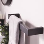 Modern black towel rail with hanging towel in a bathroom setting.