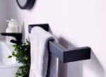 Black and silver towel rail in modern bathroom with towel and accessories.