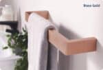 Rose Gold towel rack mounted on wall with a white towel, modern bathroom accessory.