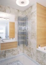 Modern heated towel rail in a stylish bathroom with beige stone tiles and wooden accents.