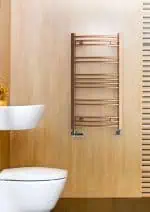Chrome towel radiator in modern bathroom setting.