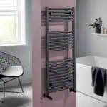 Thermostatic towel rail in modern bathroom, black heated radiator for drying towels.
