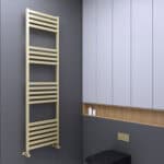 Contemporary beige towel radiator in a modern bathroom setting with blue cabinetry and textured gray wall.