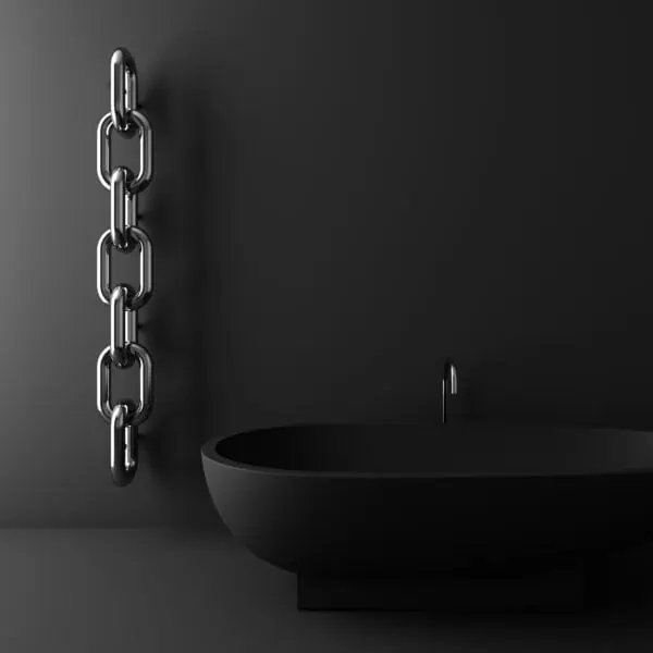 Shiny metal chain hanging on a black wall next to a black sink with a faucet, modern industrial bathroom decor.