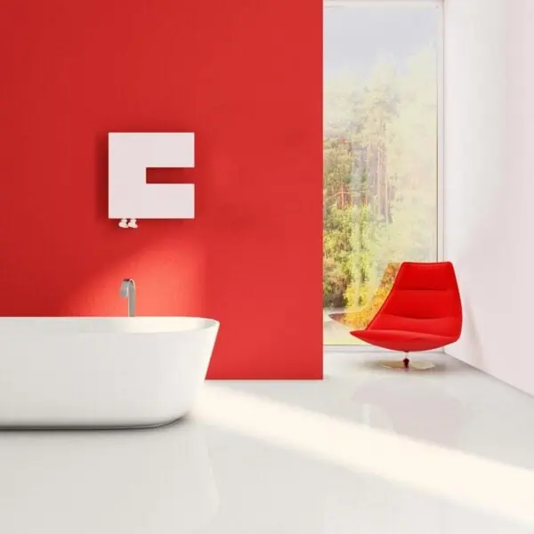 Modern bathroom with freestanding white tub, red accent wall, and contemporary red lounge chair. Bright, minimalist interior design.