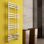 Poshrads modern white radiator on vibrant yellow wall, minimalist heating solution.
