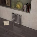 Polished metal radiator with modern design in a contemporary room setting.