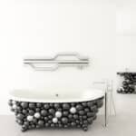 Colorful modern bathtub design with black, white, and metallic balloons, contemporary fixtures, and minimalist setting.