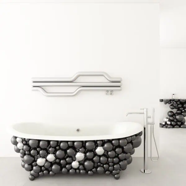 Colorful modern bathtub design with black, white, and metallic balloons, contemporary fixtures, and minimalist setting.