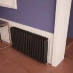 Black modern radiator installed in a stylish interior space.