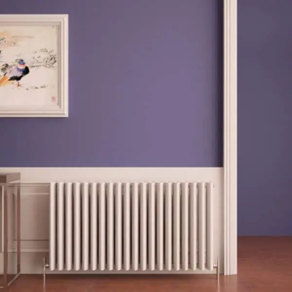 Radiator under a purple wall with framed artwork in a modern interior.
