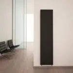 Black modern radiator in contemporary office interior.