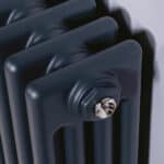 Black cast iron radiator with chrome valve detail.