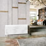 Modern minimalist white radiator in stylish living room with concrete wall and cozy seating area, eco-friendly heating solution.