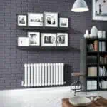 Modern interior home decor with black and white framed photos on purple brick wall, stylish shelving and radiator, cozy living space design.