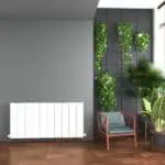 Vibrant indoor plant wall with potted greenery and modern chair in stylish living space.