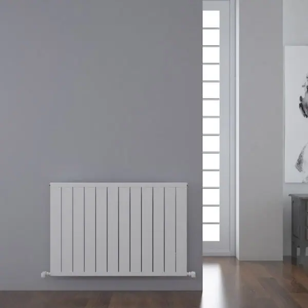 Radiator with modern grey wall and tall window with frosted glass panes in a stylish interior.