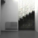 Modern minimalist interior with staircase and textured brick wall design.